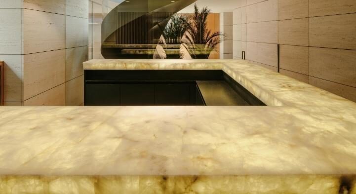 Mesa en Calacatta Gold, chimenea en Grey Stone y barra en Cuarzo.